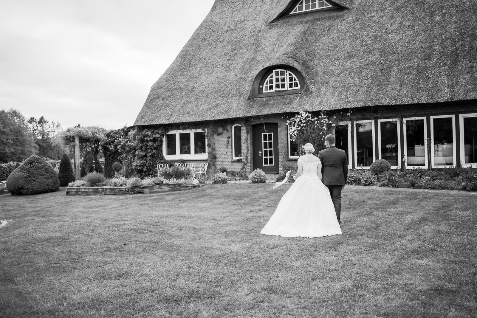 brautpaar geht ueber eine wiese