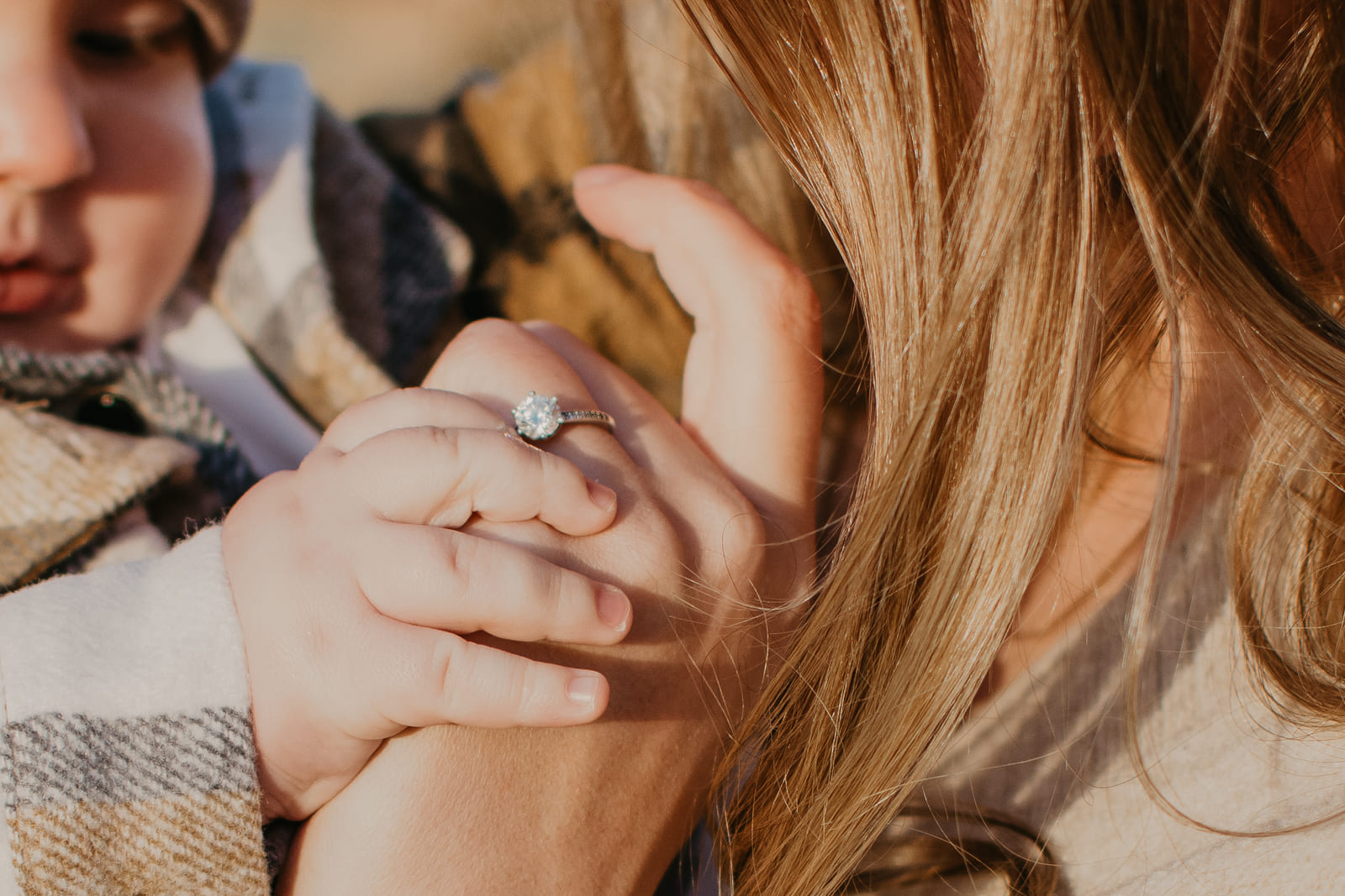 kind haelt die hand der mutter an der ein ring steckt