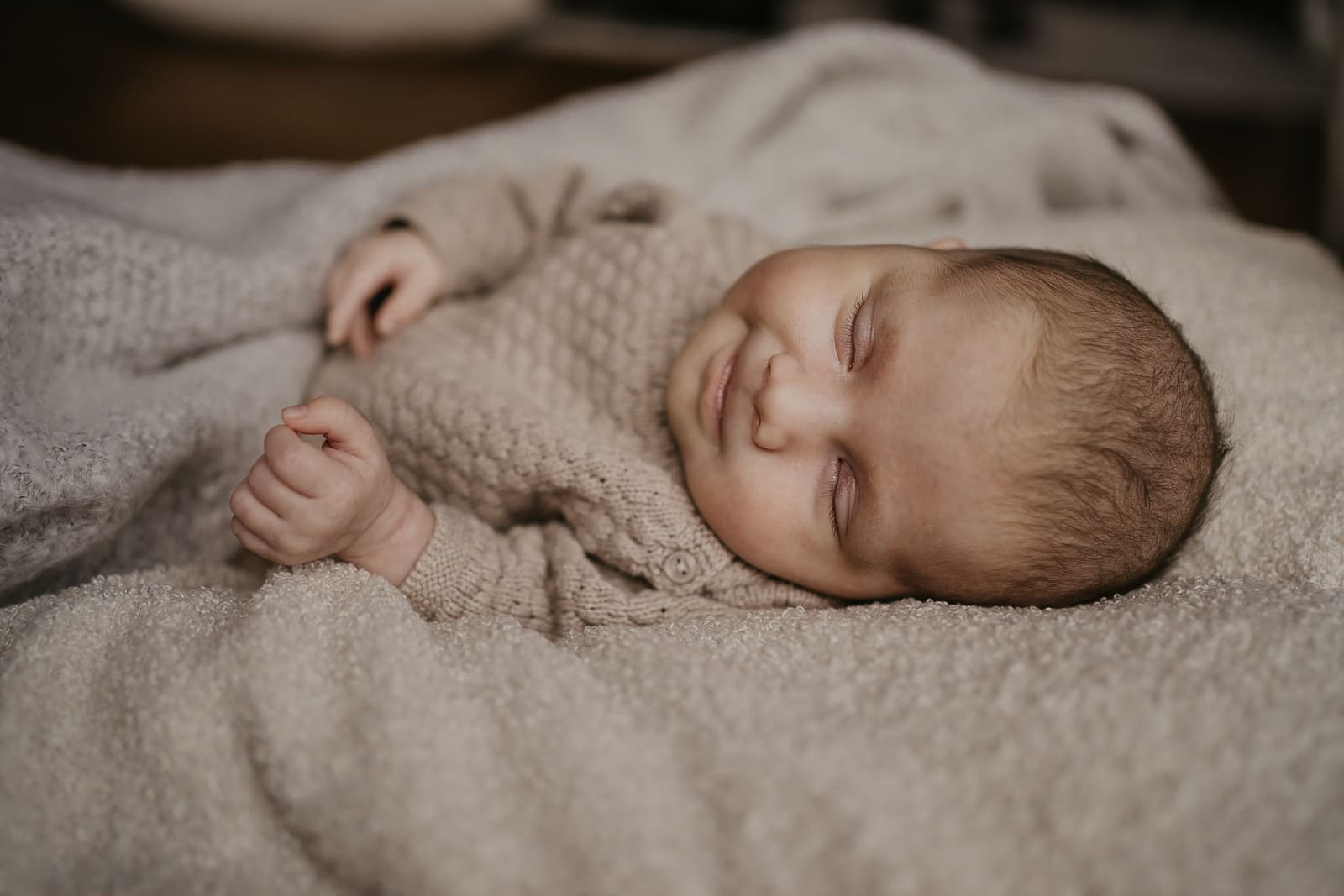 ein baby liegt auf einer decke und laechelt